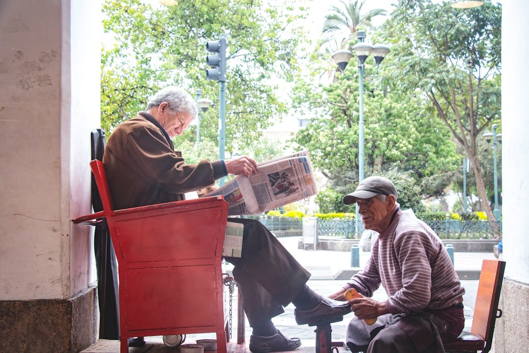 elderly people reading newspaper